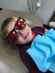 child in dentists chair during routine dental cleaning